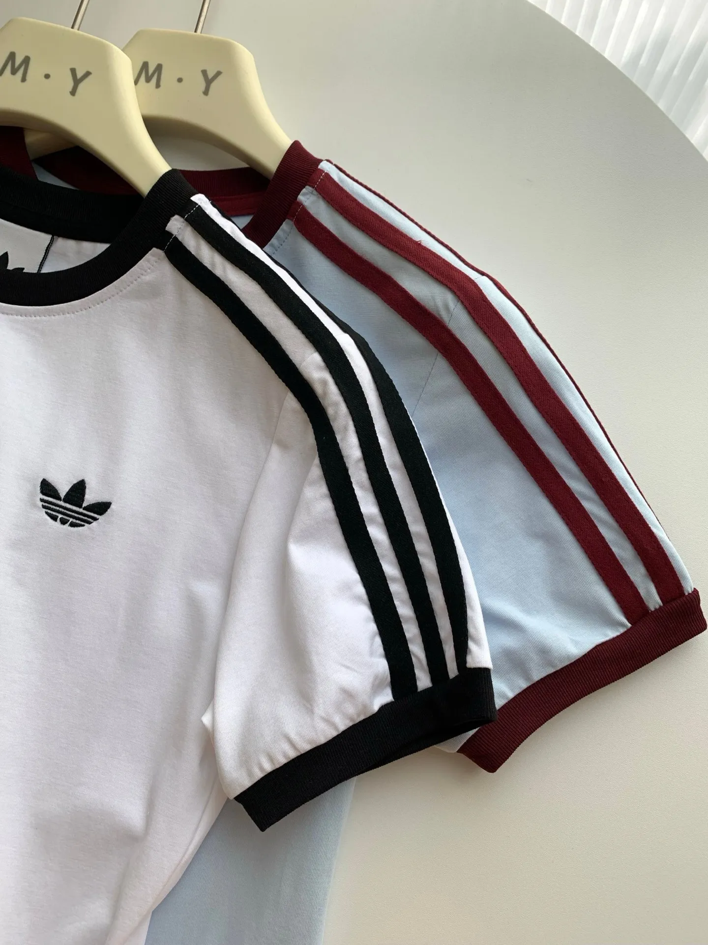 adidas Clover Retro Raglan Sleeve Short Sleeve T-shirt for Women Retro raglan sleeves + three-bar webbing, with small clover logo, full of recognition, Retro atmosphere directly fills the fabric. Selected pique fabric, skin-friendly and breathable, soft and not sweaty, daily wear without burden. Neat routing, fine workmanship, clover version texture, can be worn for daily commuting, going out, and sports. Style number: A 226# Color: apricot Light Blue Sizes: S-XL